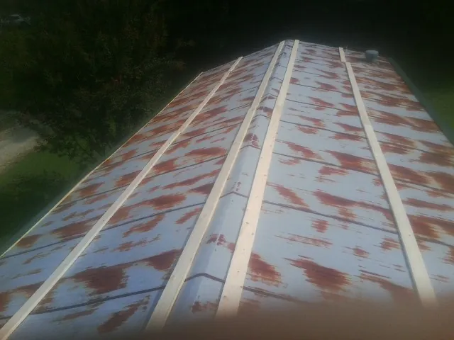Rusted metal roof panels with new wood purlins before replacement — Storm Damage Roof Repair in Alplaus by Roofing Brothers