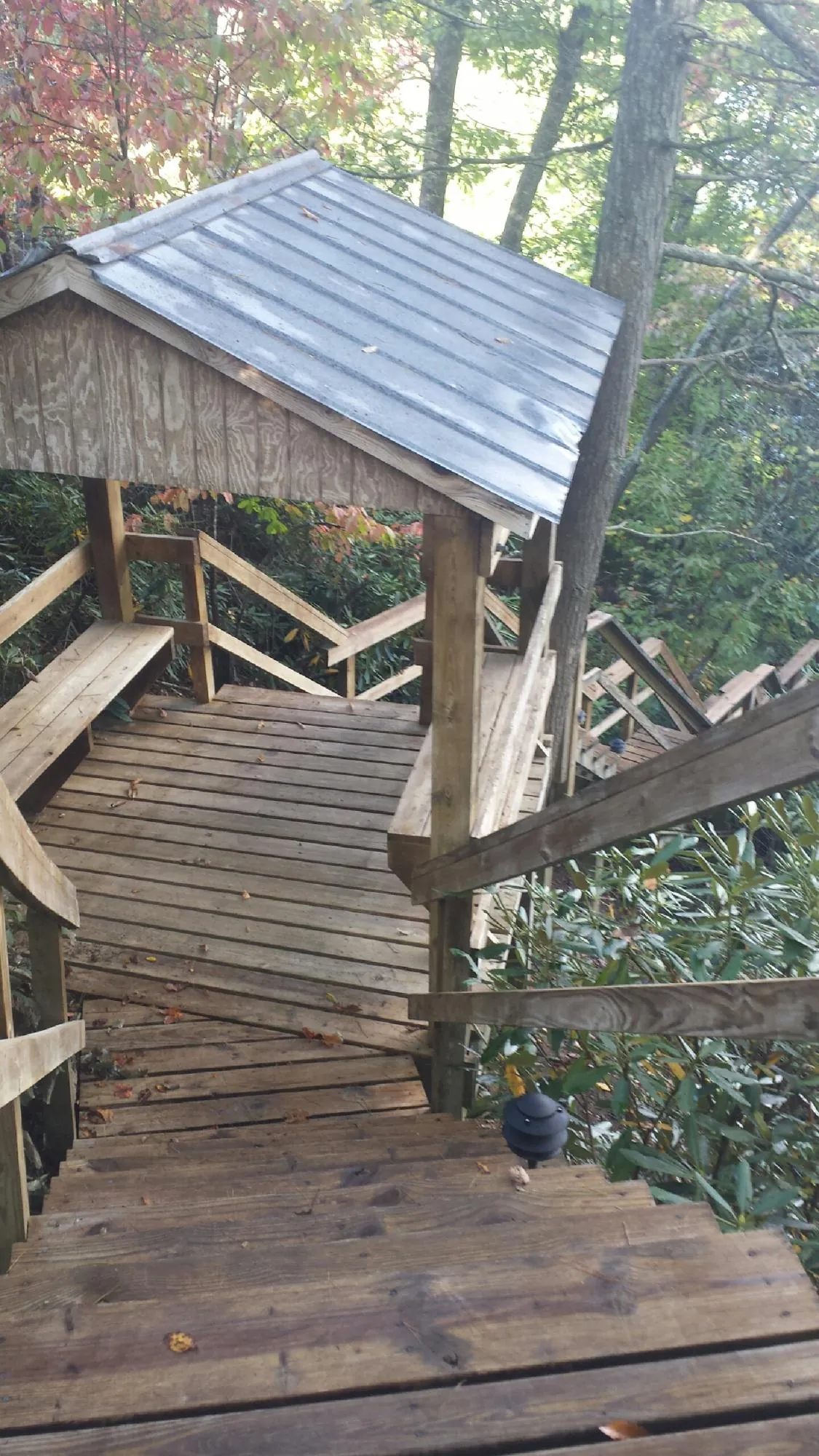 Metal roofed shelter over wooden steps on a wooded walkway — Skylight Repair & Installation work by our crew in Alplaus