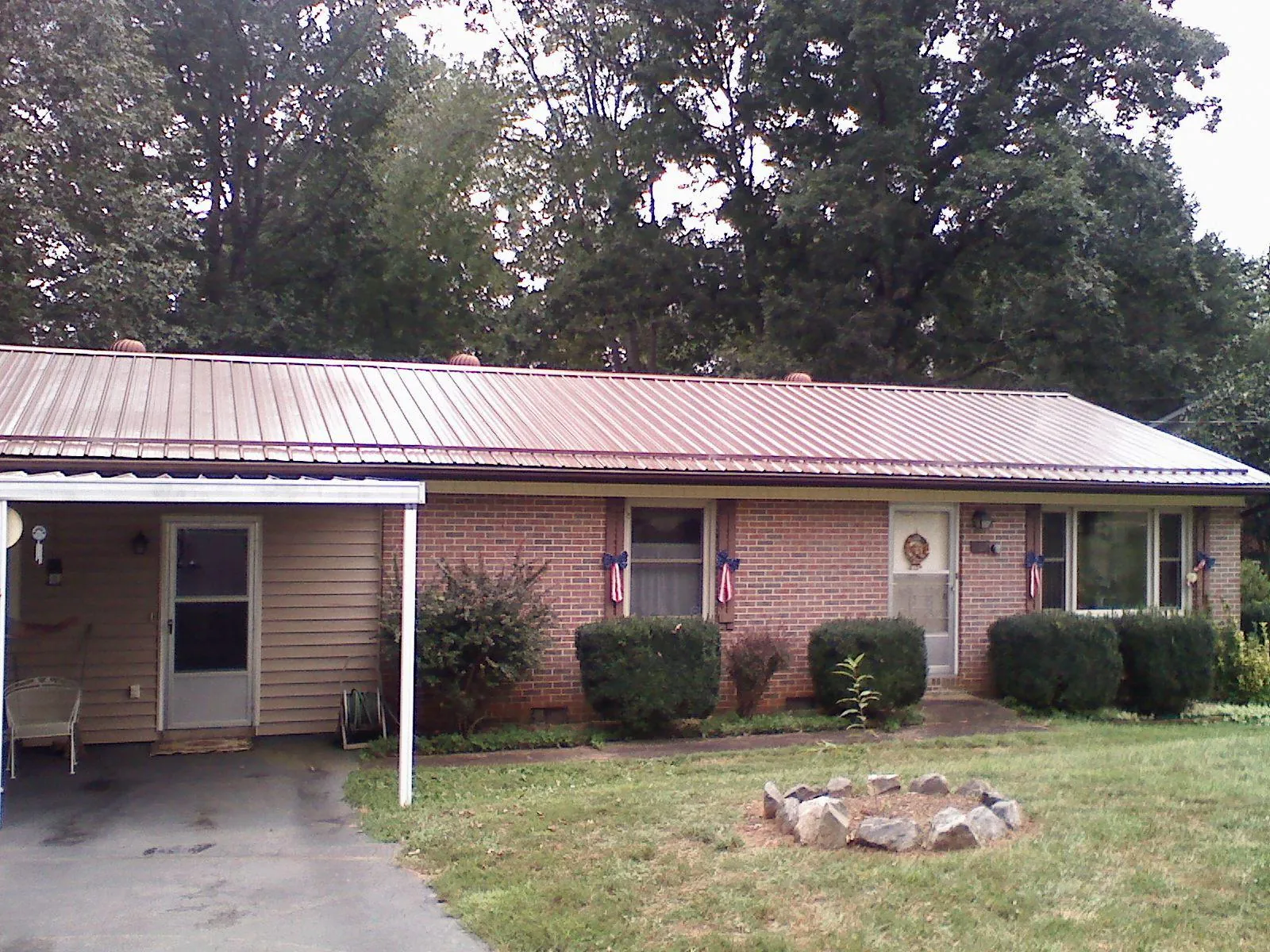 Bronze metal roof and carport on a brick ranch home — Roof Repair work by our crew in Alplaus